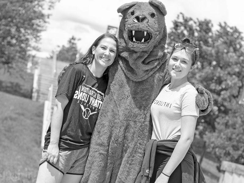 尼塔尼狮子吉祥物抱着两个学生
